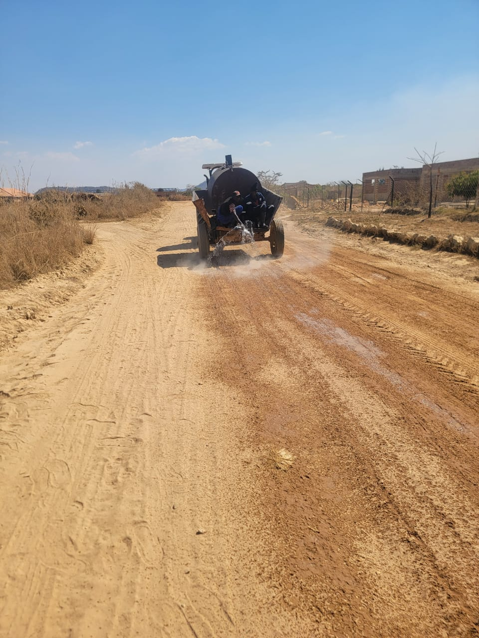 Makonde RDC water bowser applying water to an unsealed road during maintenance